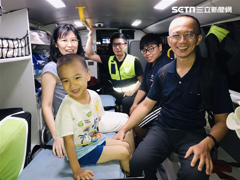 一家人坐在救護車上合影留念。(圖/翻攝畫面)